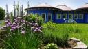 Kräuterspirale im Frühling mit blühendem Schnittlauch im Garten des Haus der Kinder im Spessart